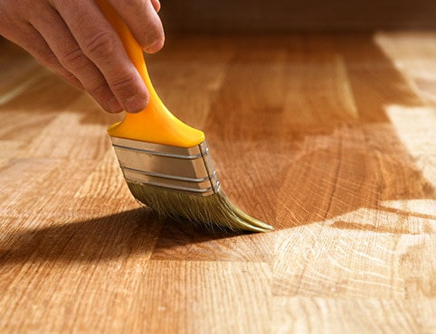 A pro painter refinishes a hardwood floor. A pro painter refinishes a hardwood floor.